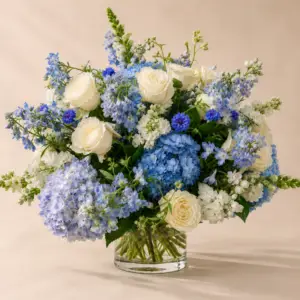 Moonlit Garden blue and white flower arrangement with white roses, blue hydrangea, delphinium, white stock, and seasonal blooms in a clear glass vase by a Santa Monica florist.