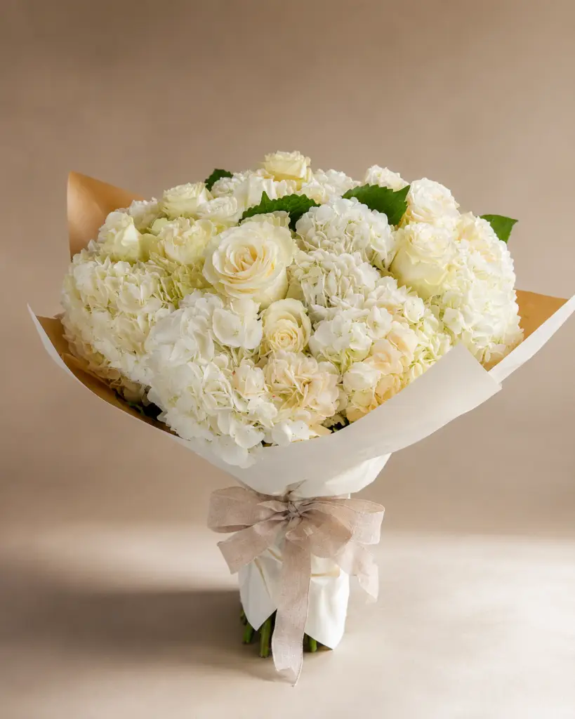 Ivory Embrace bouquet with white hydrangea, ivory roses, cream spray roses, and elegant neutral wrapping by a Santa Monica florist.
